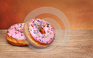 Tow Donuts with Sprinkles on wood background