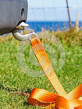 Tow hook with orange strap on car. Towing equipment