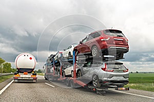 Tow truck car carrier semi trailer on highway carrying batch of damaged cars sold on insurance car auctions for repair