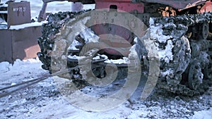 Tow truck with dirty tractor in winter. Clip. Close-up of tractor with mud and snow on winter road. Tow rope tied to