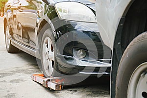 Tow truck picking up and towing broken down car on a roadside