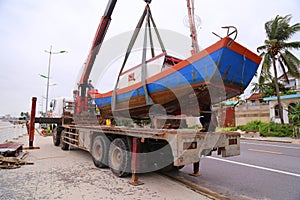 Tow truck towing fishing boat from the river