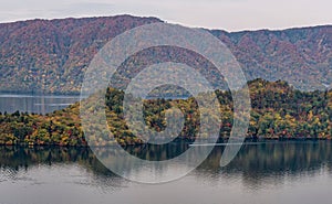 Towada lake and sight seeing boat cruising during autumn season.