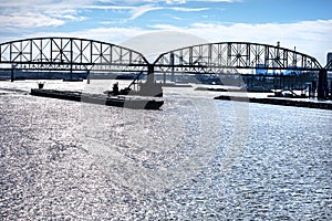 Towboat pushes dry bulk cargo barge under bridge on Mississippi River photo