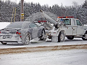 wrecker towing a car in winter photo