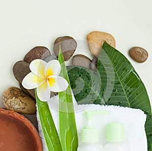 Towel, flowers, stones and green leaves and tubes