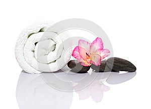 Towel, gladiola and pebbles for massage