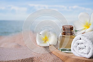 Towel and oil massage with plumeria flowers on blur blue sea