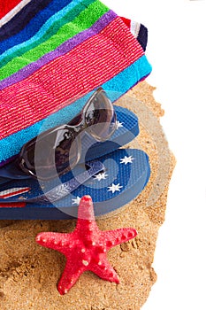 Towel and sandals on sand