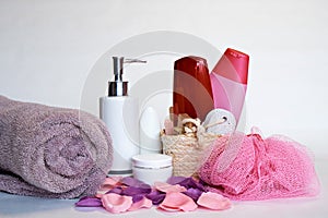 A towel and a set of spa treatments. Creams, oils, shampoos on a white background. Close-up