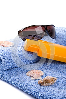 Towel, shells, sunglasses and lotion