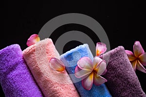Towel for spa with plumeria flowers on black background.