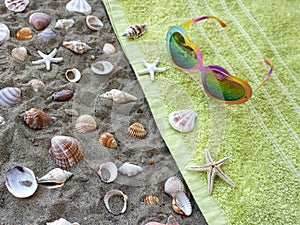 Towel and sunglasses on beach sand