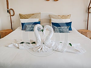 Towel white swans couple kiss heart shape on bed sheet hotel guest room decoration background