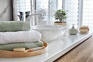 Towels and brush on table in bathroom