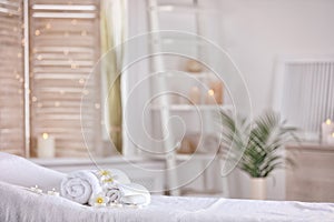 Towels and candles on massage table in modern spa salon. Place for relaxation