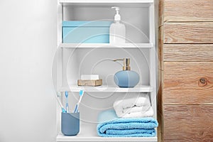 Towels, toiletries and soap dispenser on shelves