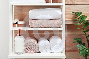 Towels, toiletries and soap dispenser on shelves