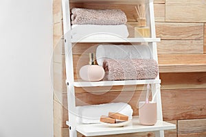 Towels, toiletries and soap dispenser on shelves