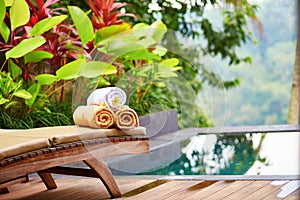 Towels with white frangipani flowers near the pool