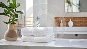 Towels on white marble desk in the foreground and blurred modern bathroom