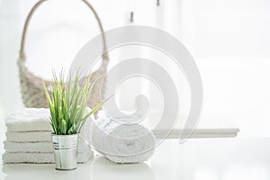 Towels on white table with copy space on blurred bathroom background