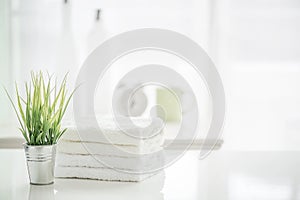 Towels on white table with copy space on blurred bathroom background