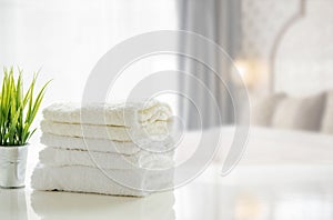 Towels on white table with copy space on blurred bedroom background