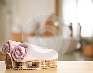 Towels on wooden table in bathroom. Space for text