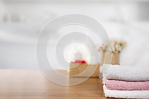 Towels on wooden top table with copy space on blurred bathroom background