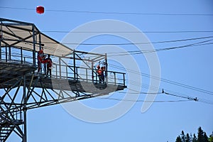 On the tower in the amusement park, a guy and a girl are getting ready to jump on the bungee jumping. Photo from afar