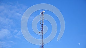 Tower antennas, GSM mobile communication against the blue sky with the moon