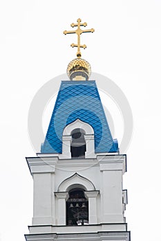 The tower with the bell of the Christian Church with blue domes and gold crosses.