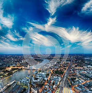 Tower Bridge and city skyline along river Thames at night, aerial view - London - UK