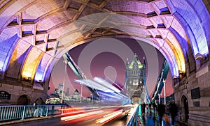 On the Tower Bridge in London after sunset with blurred red bus passing by