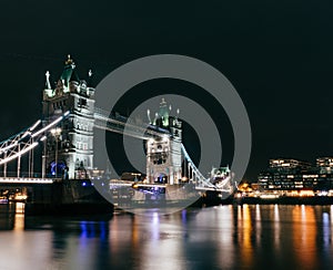 Tower Bridge of London, UK over the Thames river at night