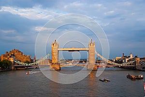 Tower bridge in London, United Kingdom. Bridge over Thames river on cloudy sky. Buildings on river banks with nice