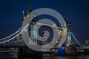 Tower bridge at night and the skyscrapers of the City of London in the background in England, UK