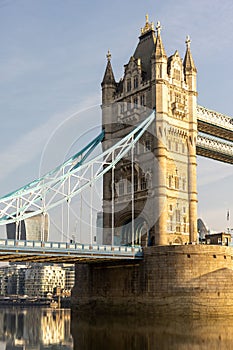 a tower bridge spanning over a river in the sun,