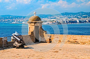 Tower and cannon of Fort Royal on Sainte-Marguerite Island. Cannes in opposite shore. Lerins Islands, France photo