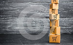 Tower of cardboard boxes with pattern of shopping carts. Purchasing power, delivery order. Sales of goods and services. E-commerce