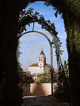 Tower of the church Iglesia de Santa Maria de la Encarnacion in the Alhambra, Granada, from the gardens of Generalife