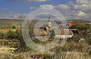 Tower of Church at Zohor village with barns