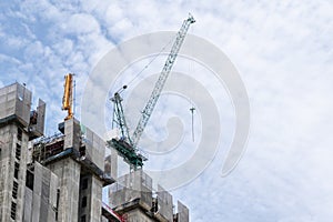 Tower construction crane in rooftop building construction site with blue sky background