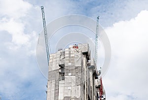 Tower construction crane in rooftop building construction site with blue sky background