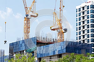 Tower construction crane in rooftop building construction site with blue sky background