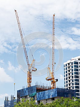 Tower construction crane in rooftop building construction site with blue sky background
