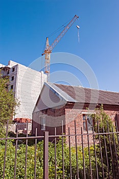 Tower construction site with crane and buildings with blue sky background