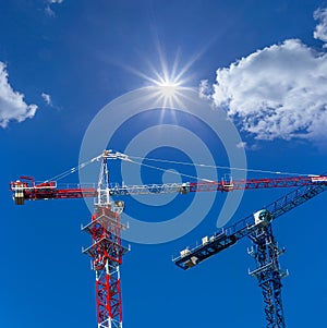 Tower crane on blue cloudy sky background