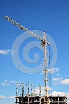 Tower Crane and building construction site with contractor on the top. Industrial building.